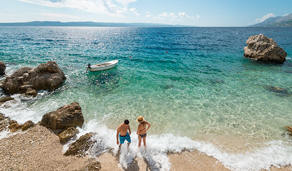 Par på strand i Brela, Kroatien