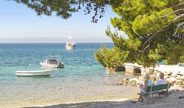 Par sitter vid stranden i Makarska, Kroatien